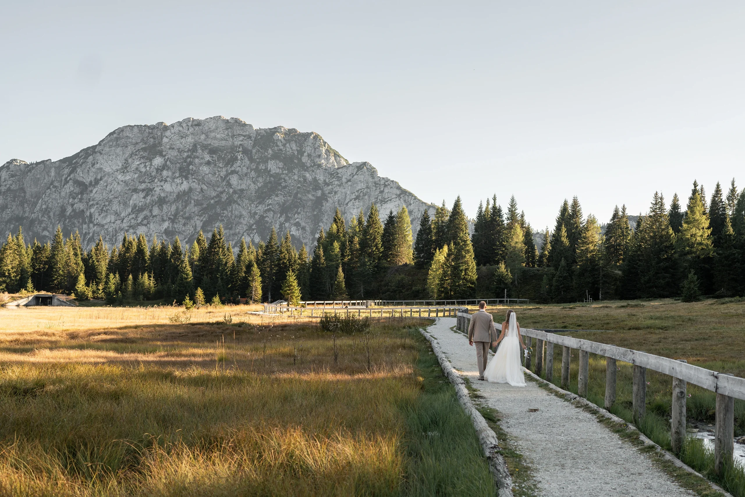 Hochzeitsfotografie Kärnten | Brautpaar spaziert | Im Hintergrund die Berge